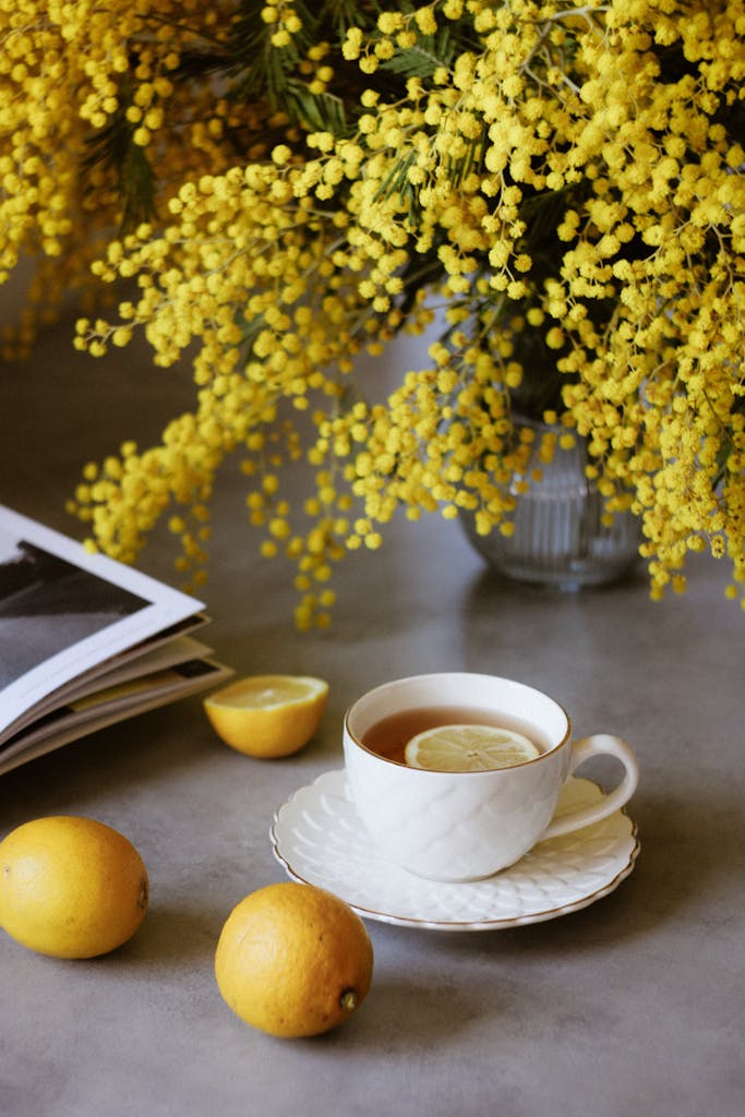 A cozy tea setting with lemons and vibrant yellow flowers, perfect for a spring morning.